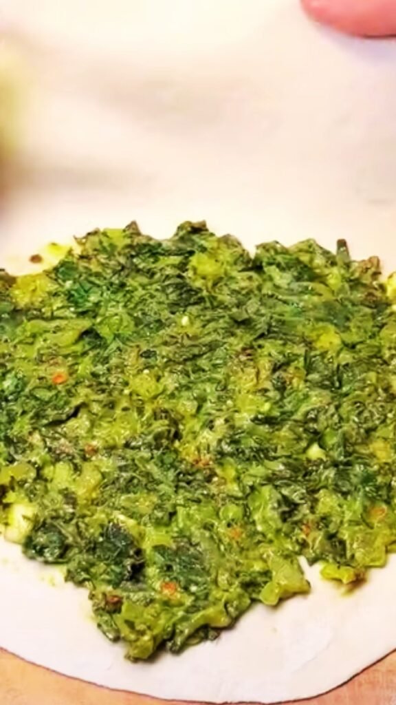 Thin dough being filled with spinach and cheese mixture